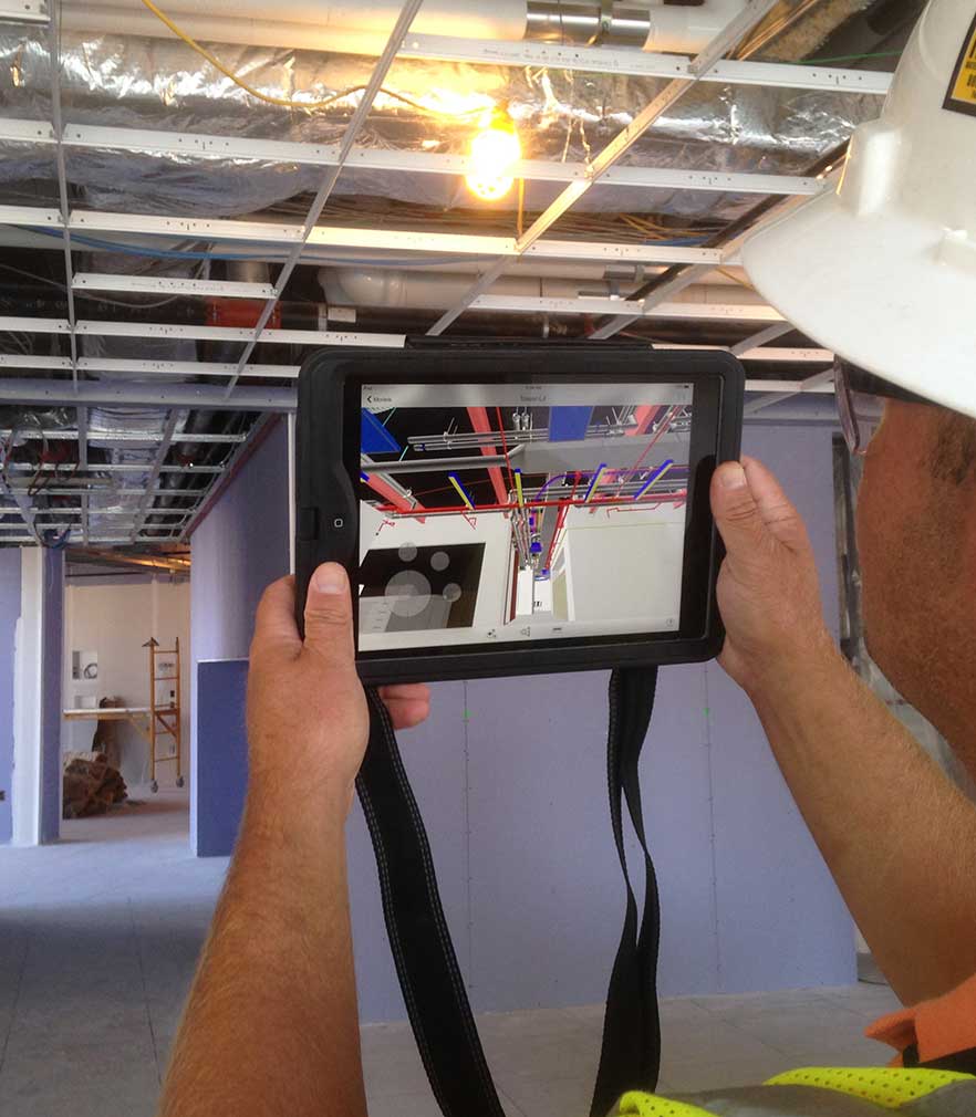 Man Holding iPad Up to Ceiling Using Laser Scanning Program