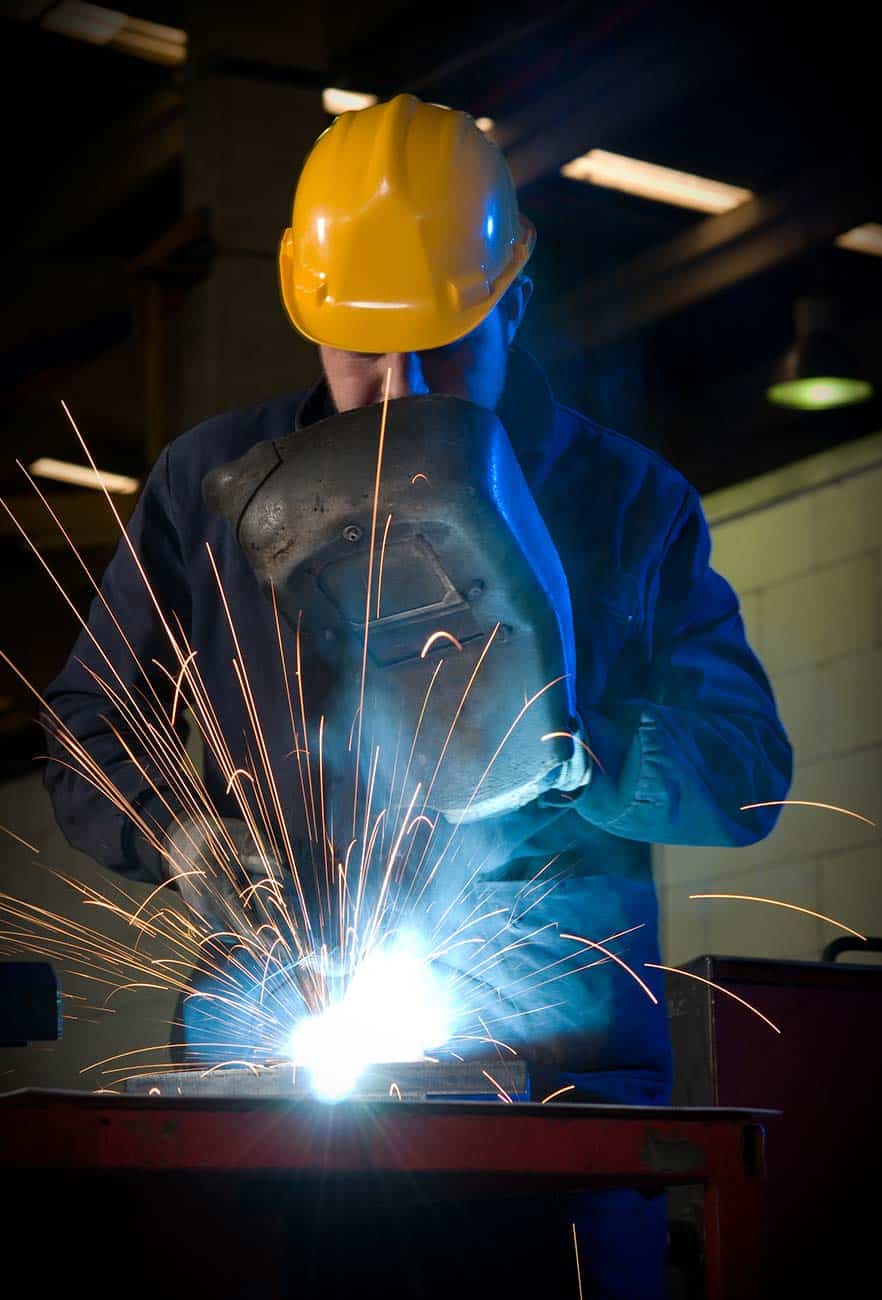 Welder with sparks flying around him as he works